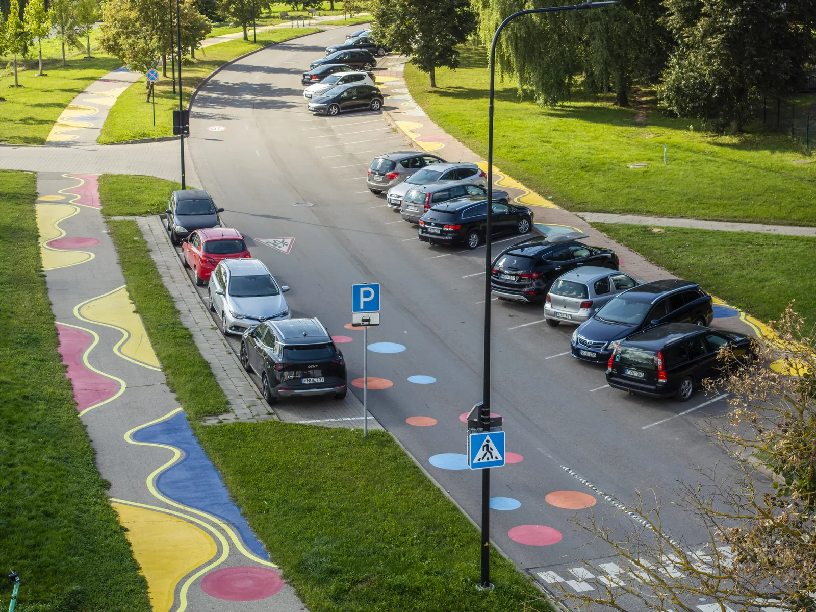 Medeinos gatvė Pašilaičiuose iš viršaus: spalvotas važiuojamosios dalies ženklinimas ir automobilių stovėjimo aikštelė